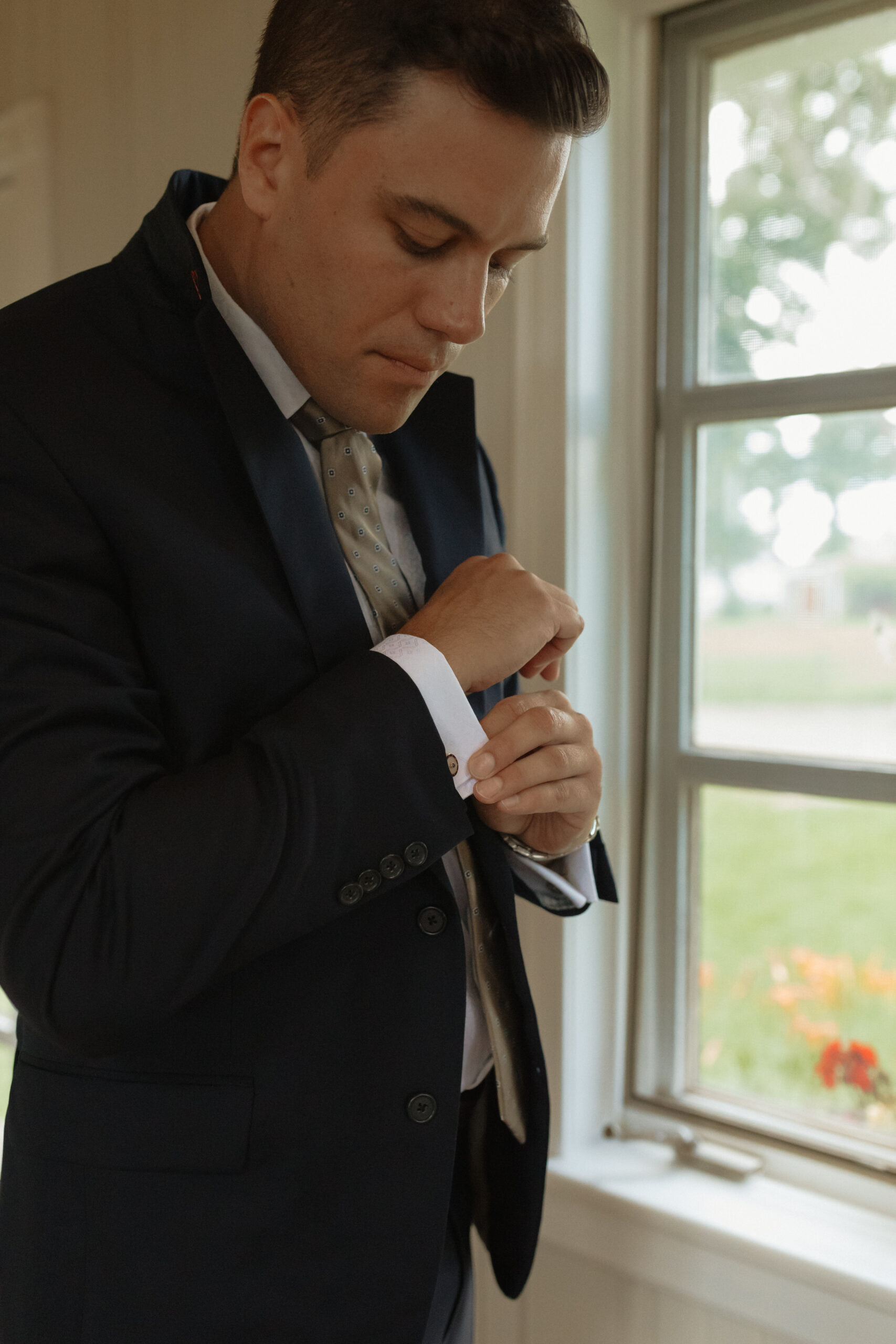 groom buttoning his sleeves