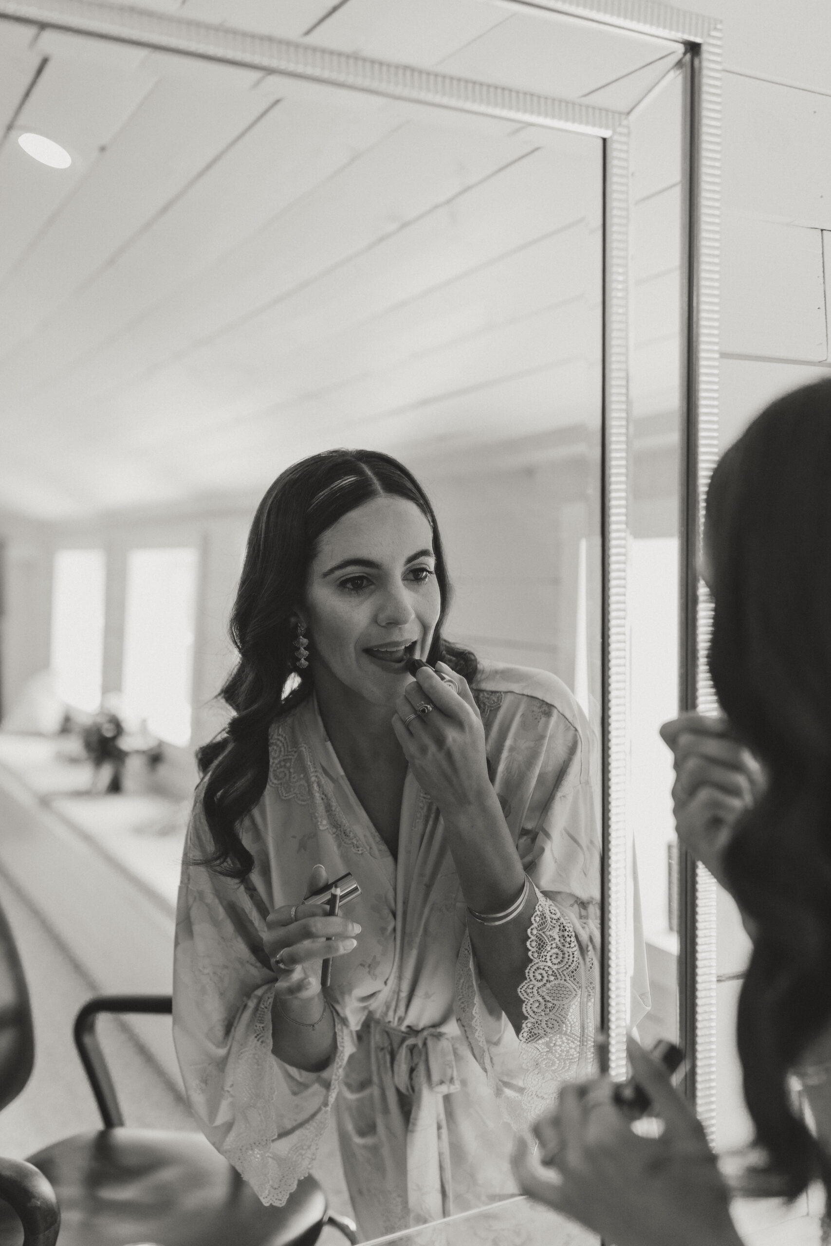 bride putting on lipstick in mirror