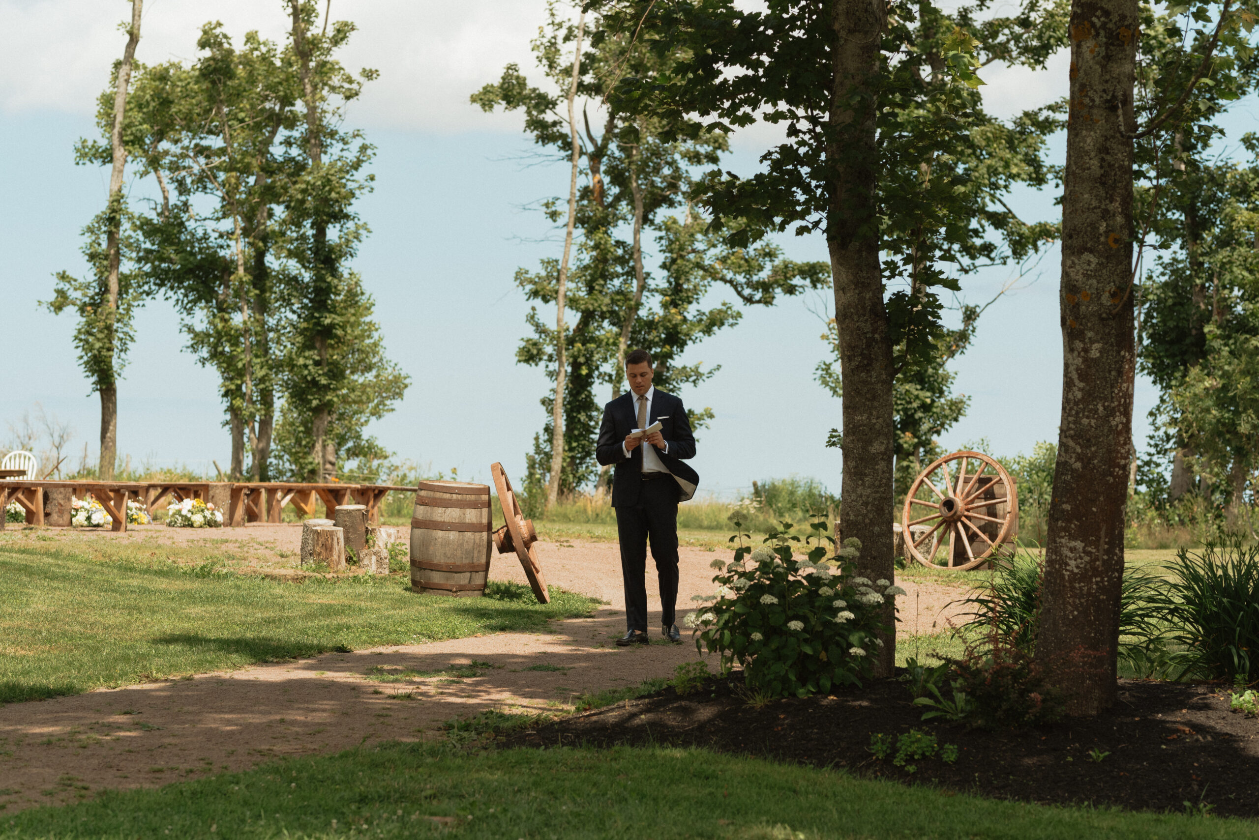 groom walking while reading vows at New London carriage house in PEI