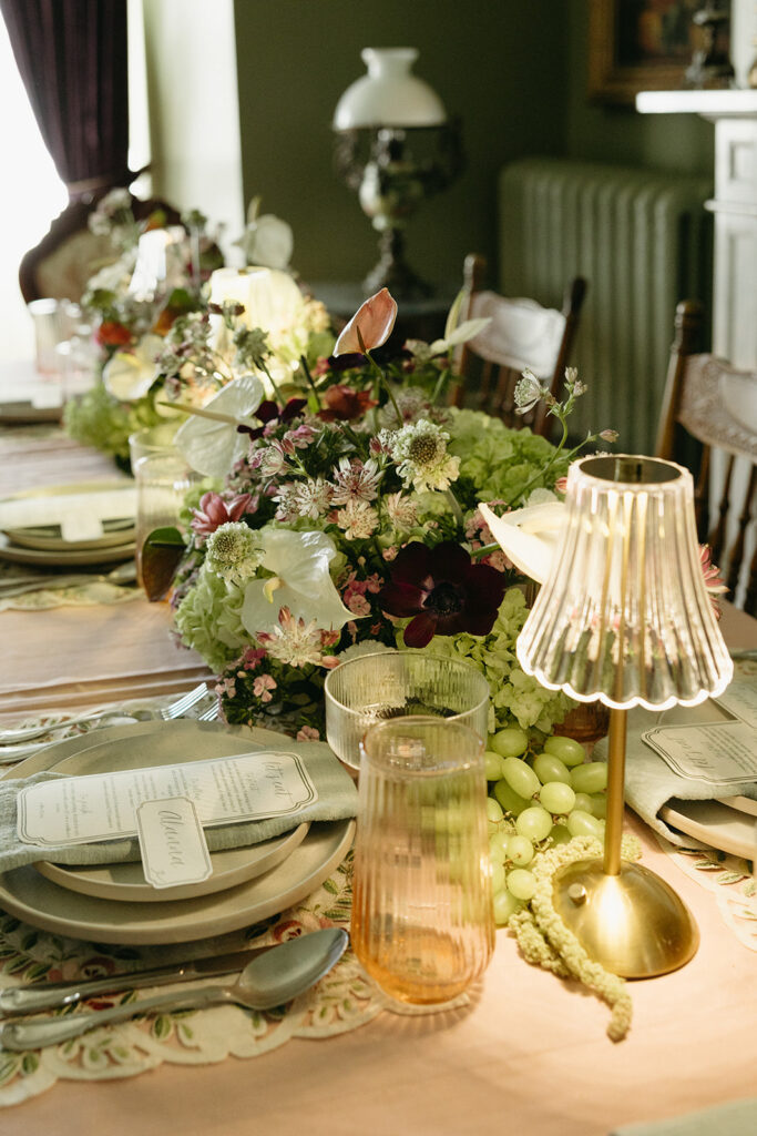 table photo of wedding dinner table with lamps, flowers, grapes