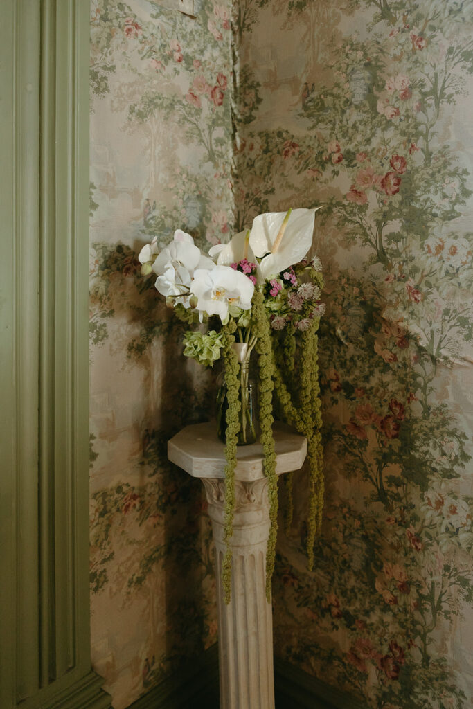 Bridal bouquet on pedestal infant of vintage wallpaper 