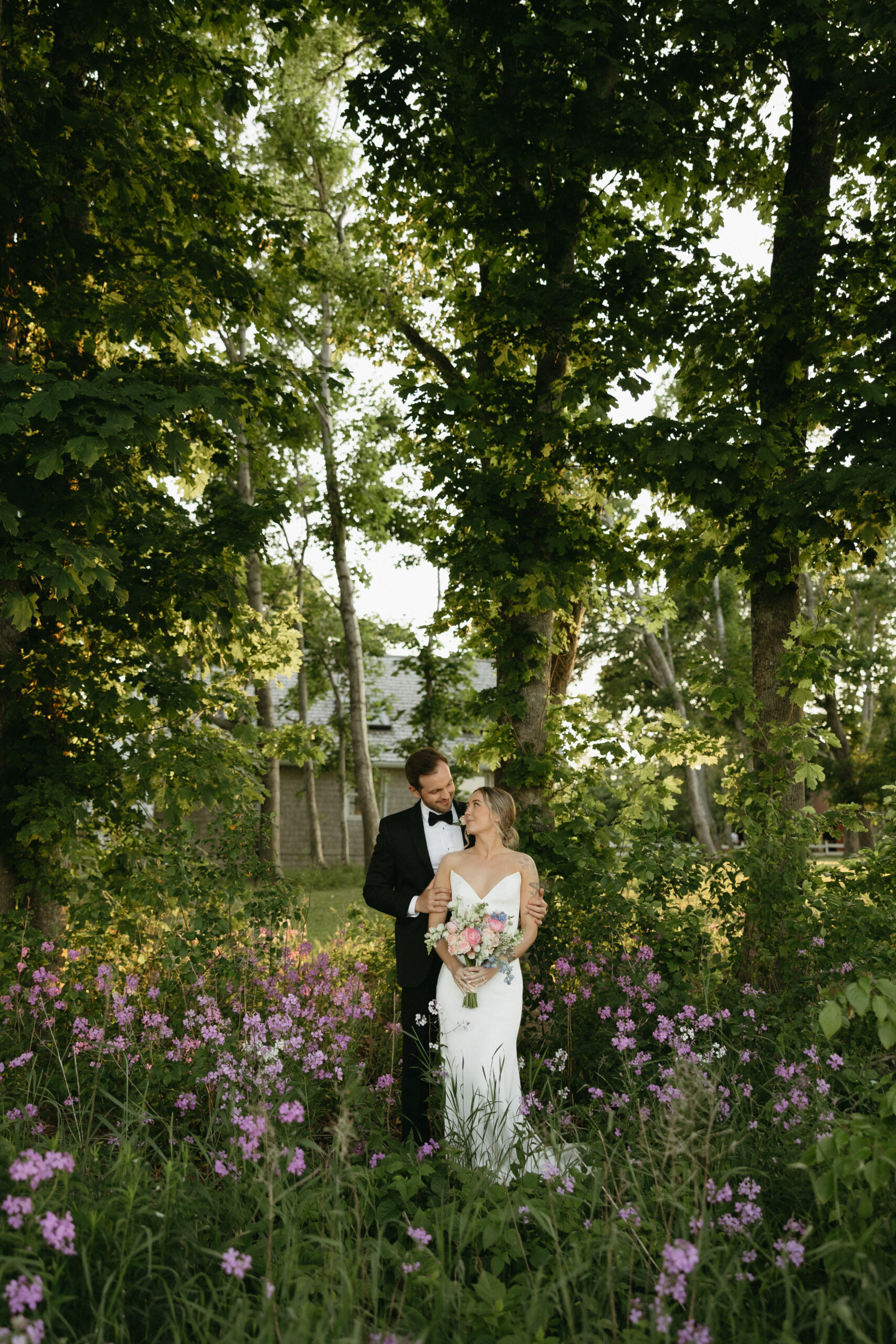 couple standing in a field of wildflowers looking at each other